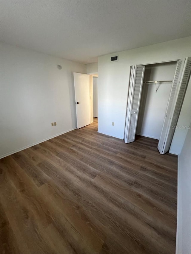 unfurnished bedroom with dark hardwood / wood-style flooring