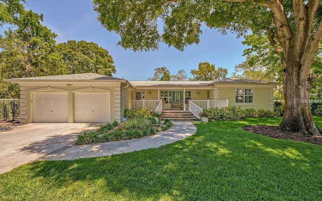 ranch-style home featuring a front lawn, covered porch, and a garage