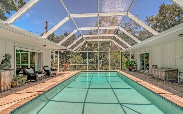 view of pool featuring glass enclosure and a patio