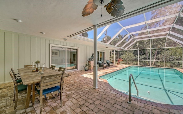 view of swimming pool featuring glass enclosure, ceiling fan, and a patio