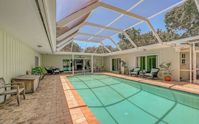 view of swimming pool featuring ceiling fan, a lanai, and a patio