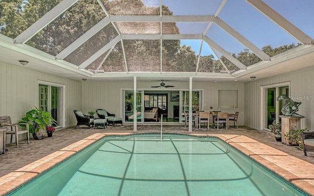 view of swimming pool featuring ceiling fan, a patio, and a lanai