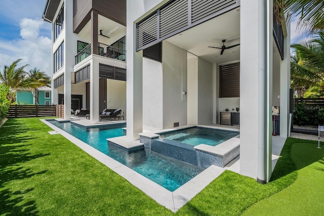 rear view of house featuring a swimming pool with hot tub, a patio, a balcony, and ceiling fan