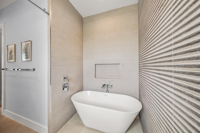 bathroom with tile patterned floors, a bath, and tile walls