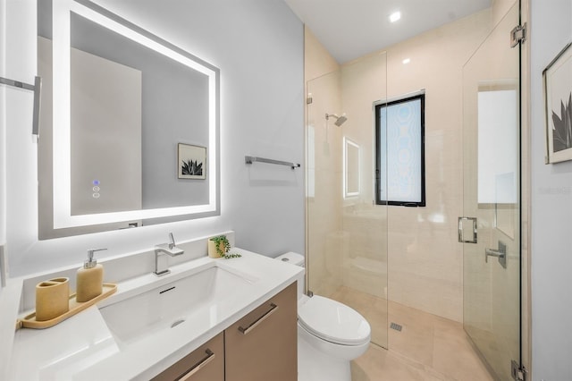 bathroom featuring vanity, toilet, and a shower with shower door