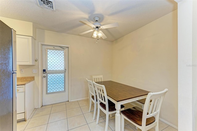 dining room featuring ceiling fan, light tile patterned floors, and a textured ceiling