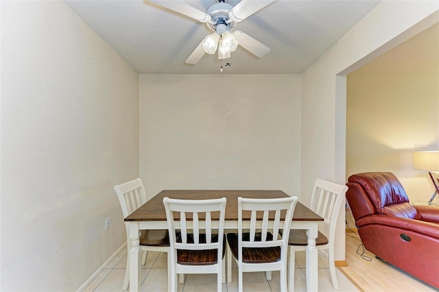 tiled dining space with ceiling fan