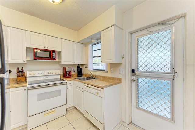 kitchen featuring white cabinetry, sink, a textured ceiling, white appliances, and light tile patterned flooring