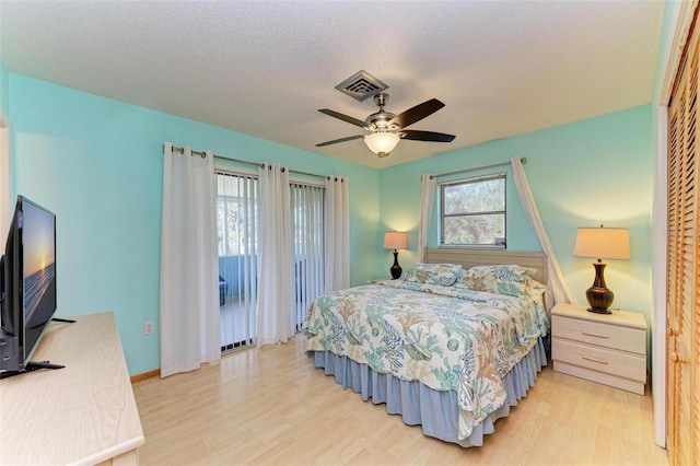 bedroom featuring ceiling fan, light hardwood / wood-style flooring, and a textured ceiling