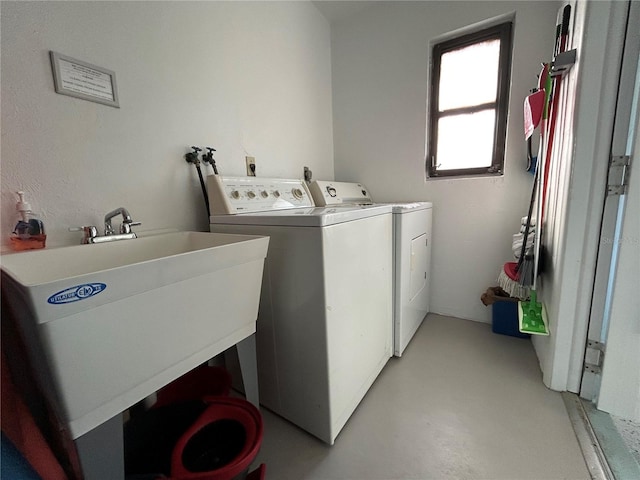 clothes washing area with sink and independent washer and dryer