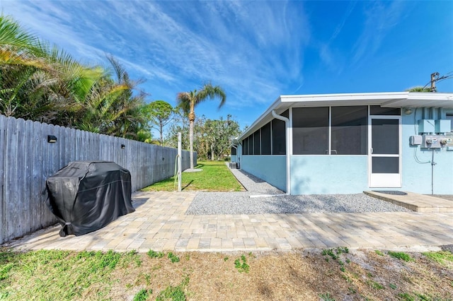 view of yard featuring a sunroom and a patio