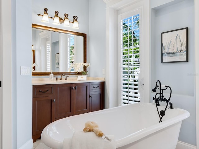 bathroom with a wealth of natural light, a washtub, and vanity