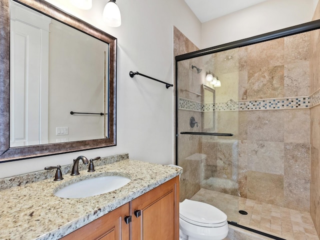 bathroom with an enclosed shower, vanity, and toilet