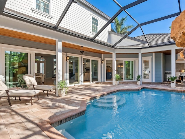 view of pool with french doors, glass enclosure, ceiling fan, and a patio area