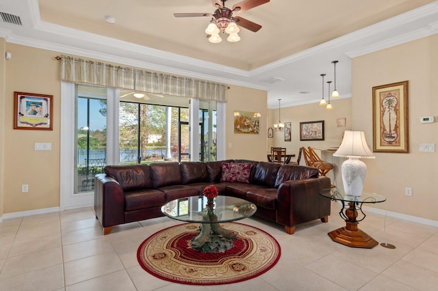 living room featuring a raised ceiling, crown molding, light tile patterned floors, and ceiling fan