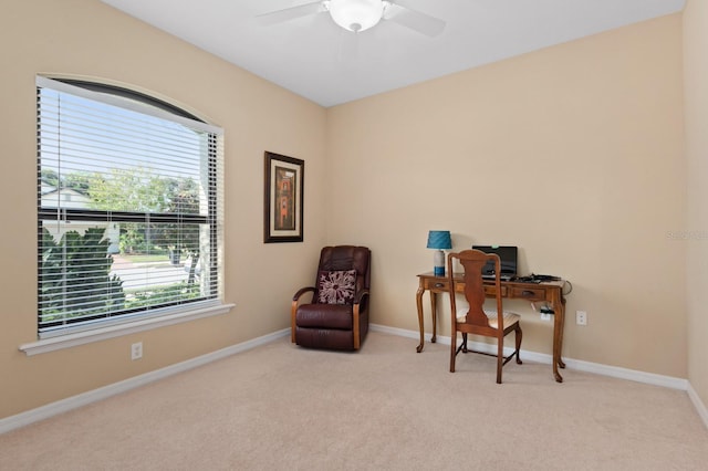 sitting room featuring light carpet, ceiling fan, and a healthy amount of sunlight