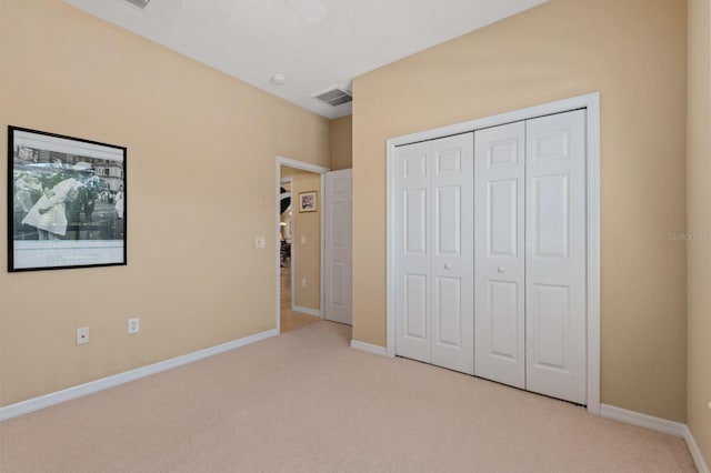 unfurnished bedroom featuring a closet and light colored carpet