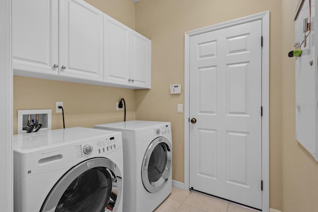 washroom with cabinets, light tile patterned floors, and washer and dryer