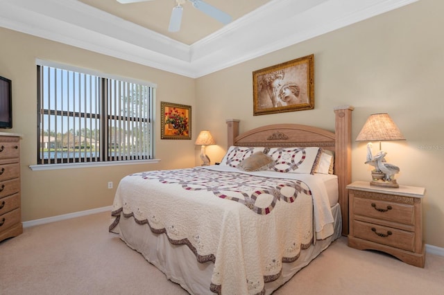 bedroom featuring a tray ceiling, ceiling fan, crown molding, and light colored carpet