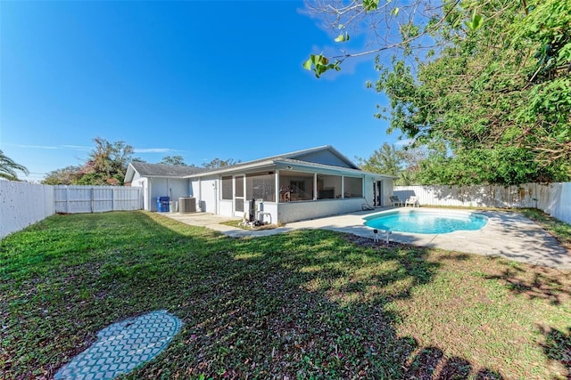 rear view of property with a fenced in pool, a sunroom, a lawn, and cooling unit