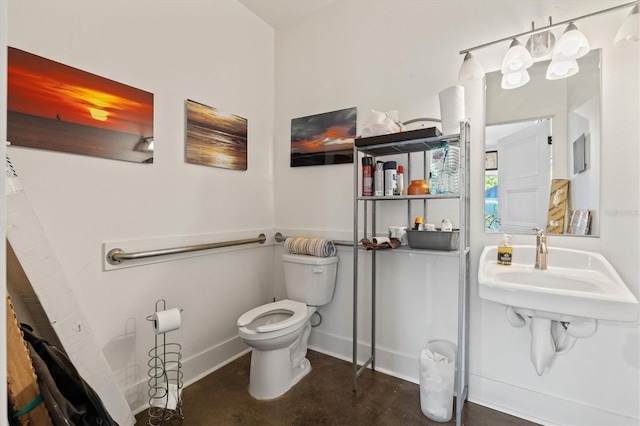 bathroom featuring sink, concrete flooring, and toilet