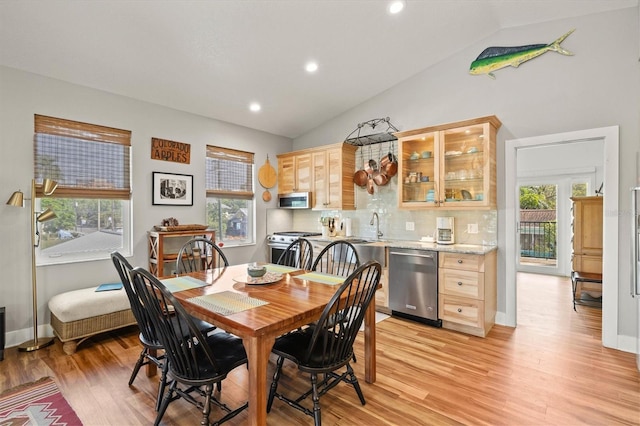 dining room with light hardwood / wood-style flooring and vaulted ceiling