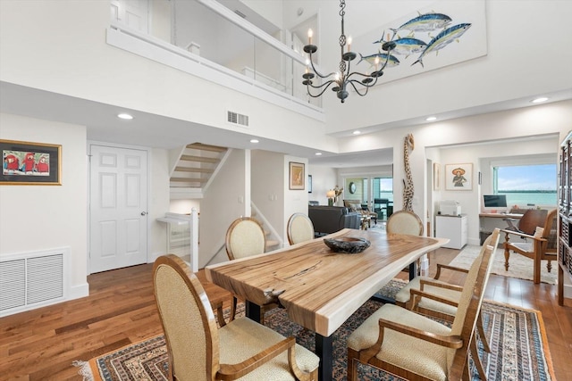 dining area featuring a wealth of natural light, a high ceiling, and hardwood / wood-style flooring