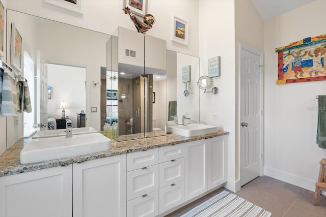 bathroom featuring tile patterned flooring, vanity, toilet, and a shower with door