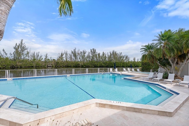 view of swimming pool with a patio area and a water view