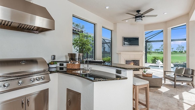 view of patio / terrace featuring ceiling fan, a grill, a lanai, and a wet bar