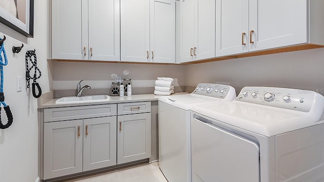 laundry room featuring cabinets, washing machine and dryer, and sink