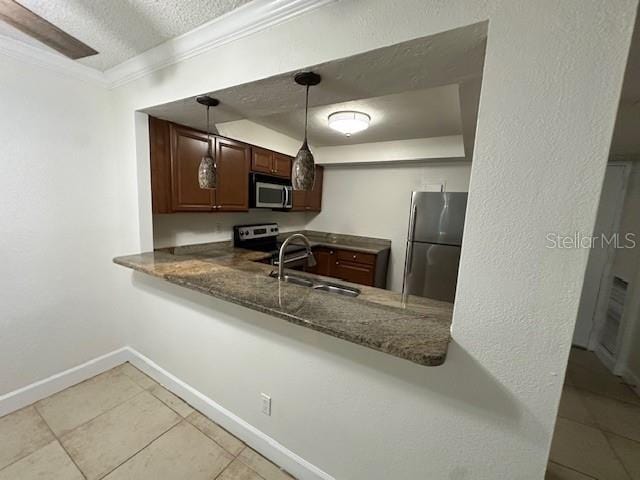 kitchen featuring kitchen peninsula, a textured ceiling, stainless steel appliances, sink, and pendant lighting