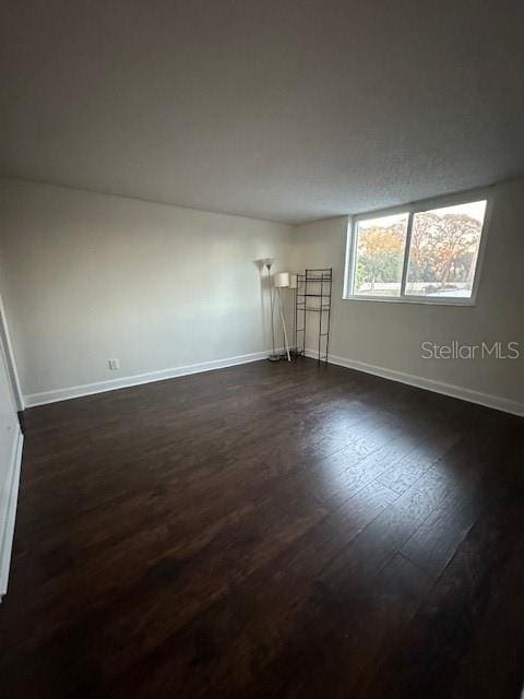 empty room with dark hardwood / wood-style floors