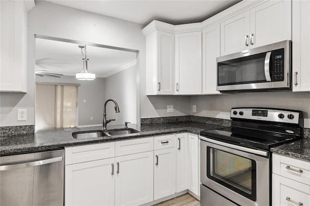 kitchen featuring white cabinetry, appliances with stainless steel finishes, sink, and dark stone countertops