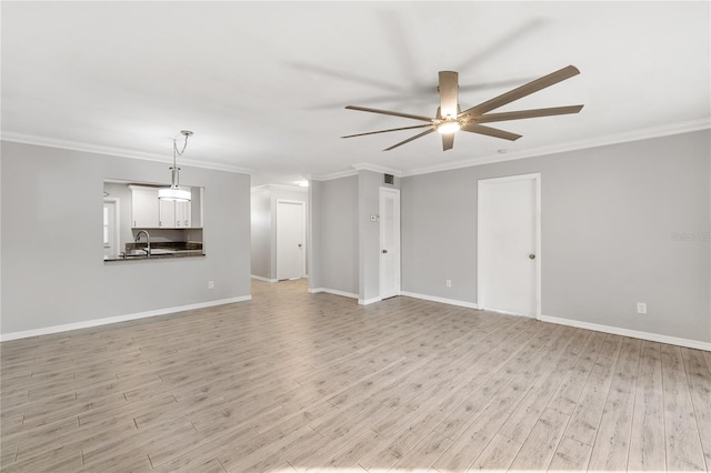 unfurnished living room featuring ornamental molding, sink, ceiling fan, and light wood-type flooring