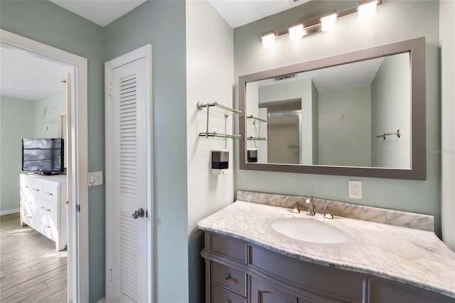 bathroom featuring vanity, hardwood / wood-style floors, and walk in shower