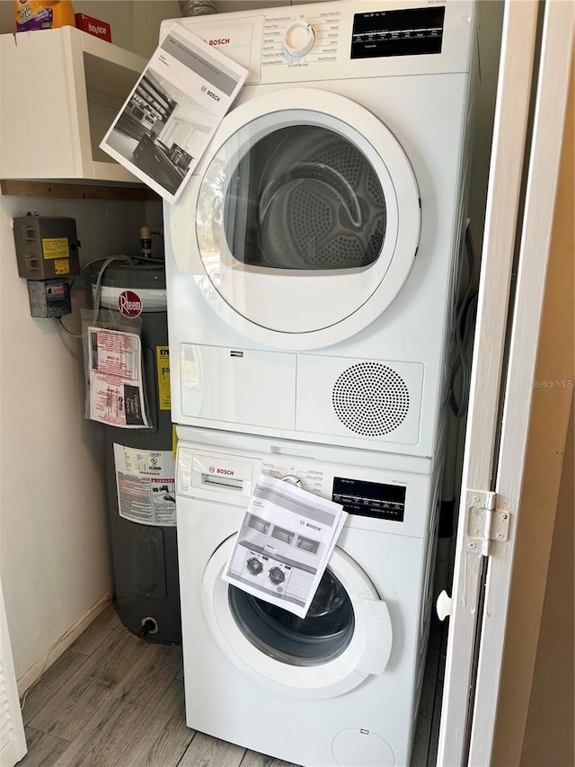 laundry room featuring stacked washer / dryer, water heater, and light wood-type flooring