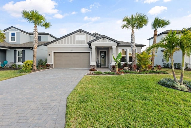 view of front of home with an attached garage, decorative driveway, board and batten siding, and a front yard