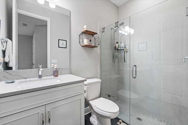 bathroom featuring vanity, toilet, and a shower with door