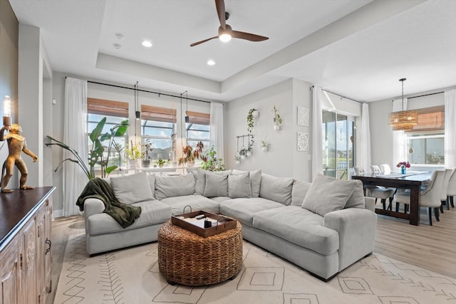 living room with ceiling fan, plenty of natural light, and light wood-type flooring