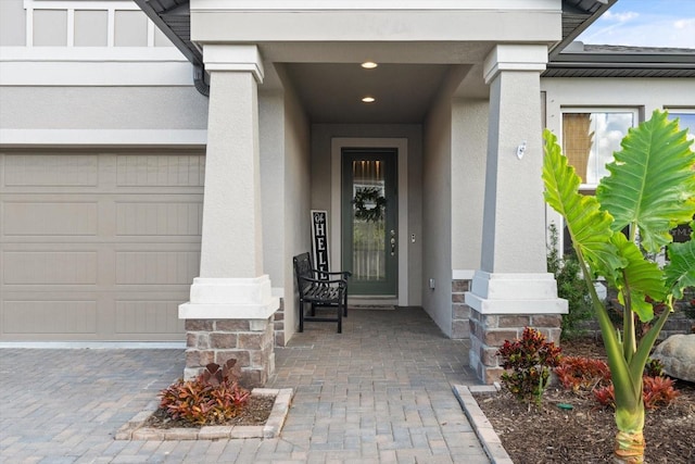 doorway to property featuring a garage and stucco siding