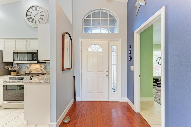 entrance foyer featuring light tile patterned flooring and a towering ceiling