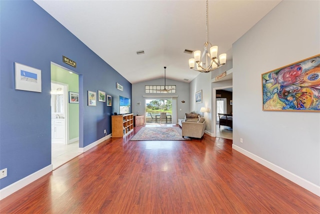 unfurnished living room with wood-type flooring, lofted ceiling, and a chandelier