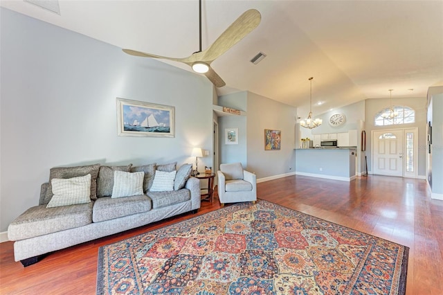 living room featuring ceiling fan with notable chandelier, dark hardwood / wood-style floors, and lofted ceiling