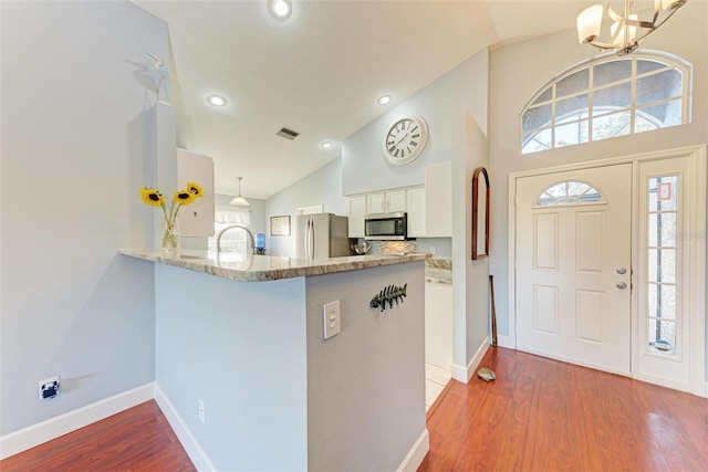 foyer entrance featuring a chandelier, hardwood / wood-style floors, a healthy amount of sunlight, and sink