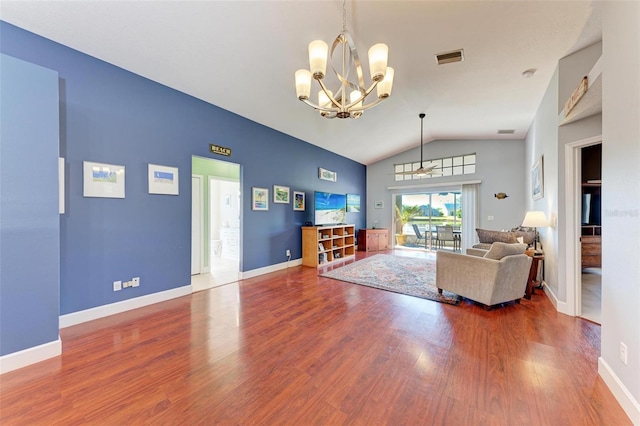 living room with an inviting chandelier, wood-type flooring, and vaulted ceiling