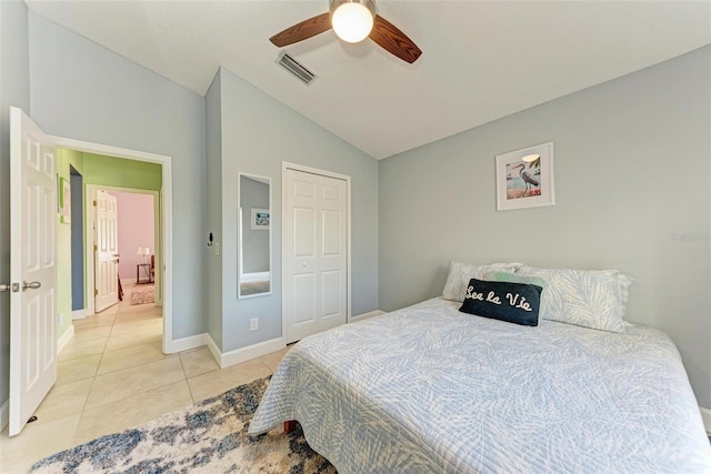 bedroom with light tile patterned floors, a closet, vaulted ceiling, and ceiling fan