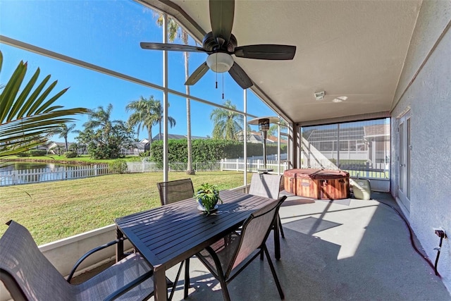 sunroom featuring ceiling fan, a healthy amount of sunlight, a water view, and vaulted ceiling