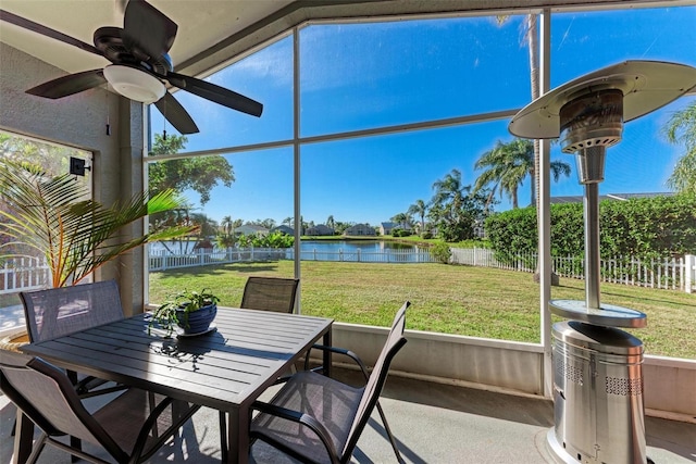 sunroom / solarium featuring ceiling fan and a water view