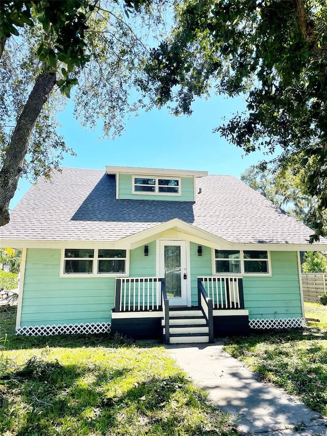 bungalow-style home with covered porch and a front yard